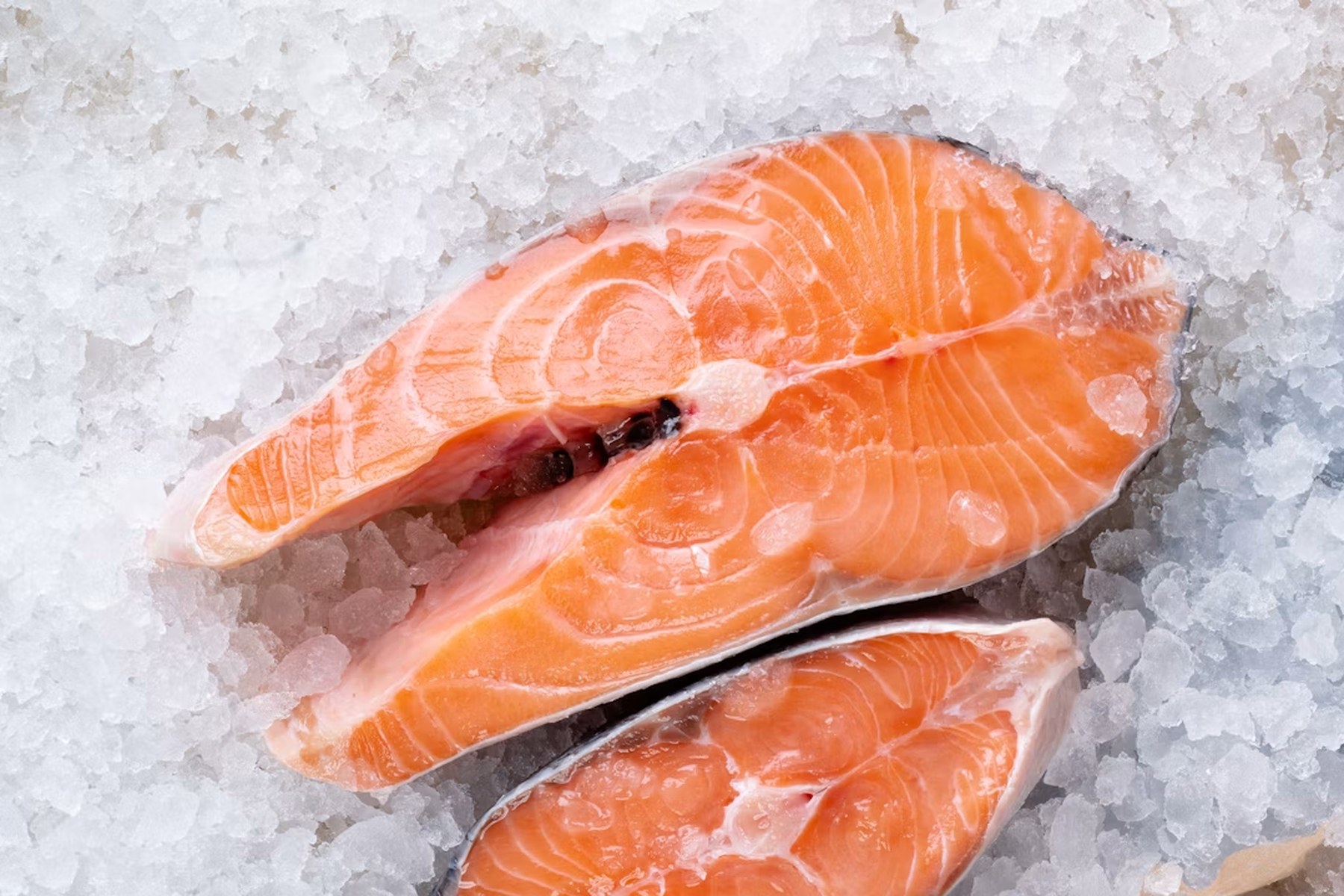 Fresh raw salmon steaks on ice, cold chain freshness
